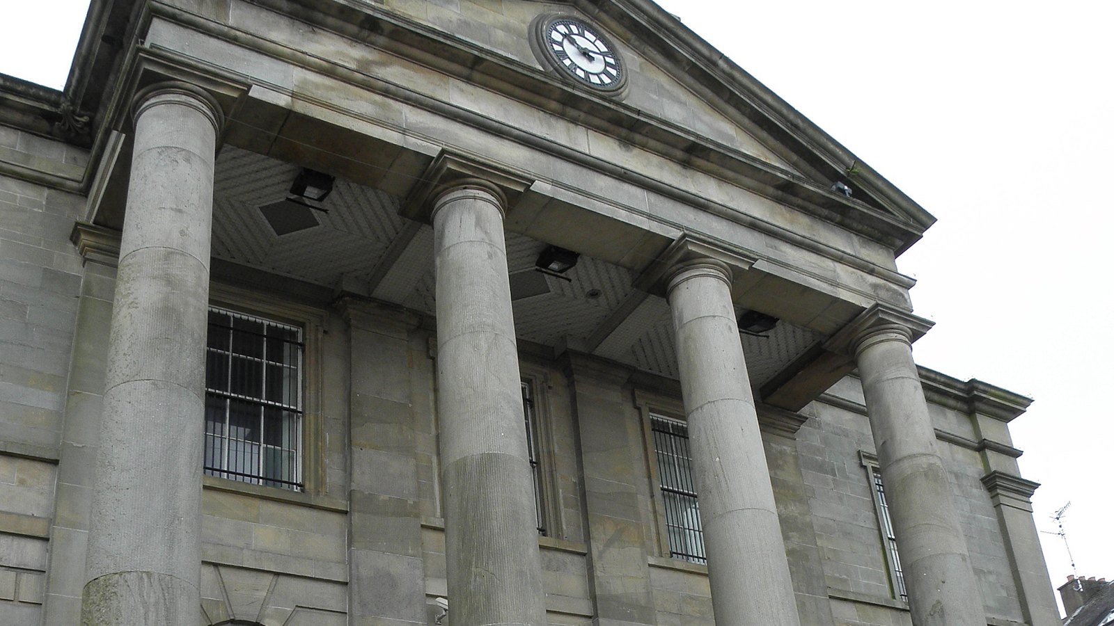 Tall sandstone columns and the pediment of a courthouse portico