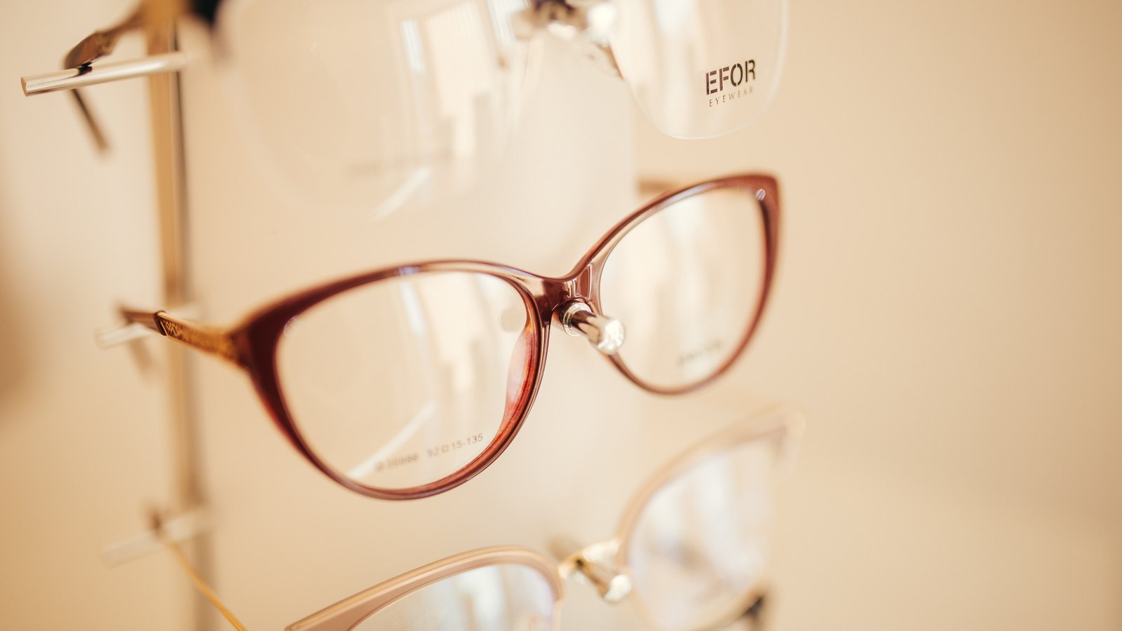 Eyeglass frames hanging on a display rack in a shop