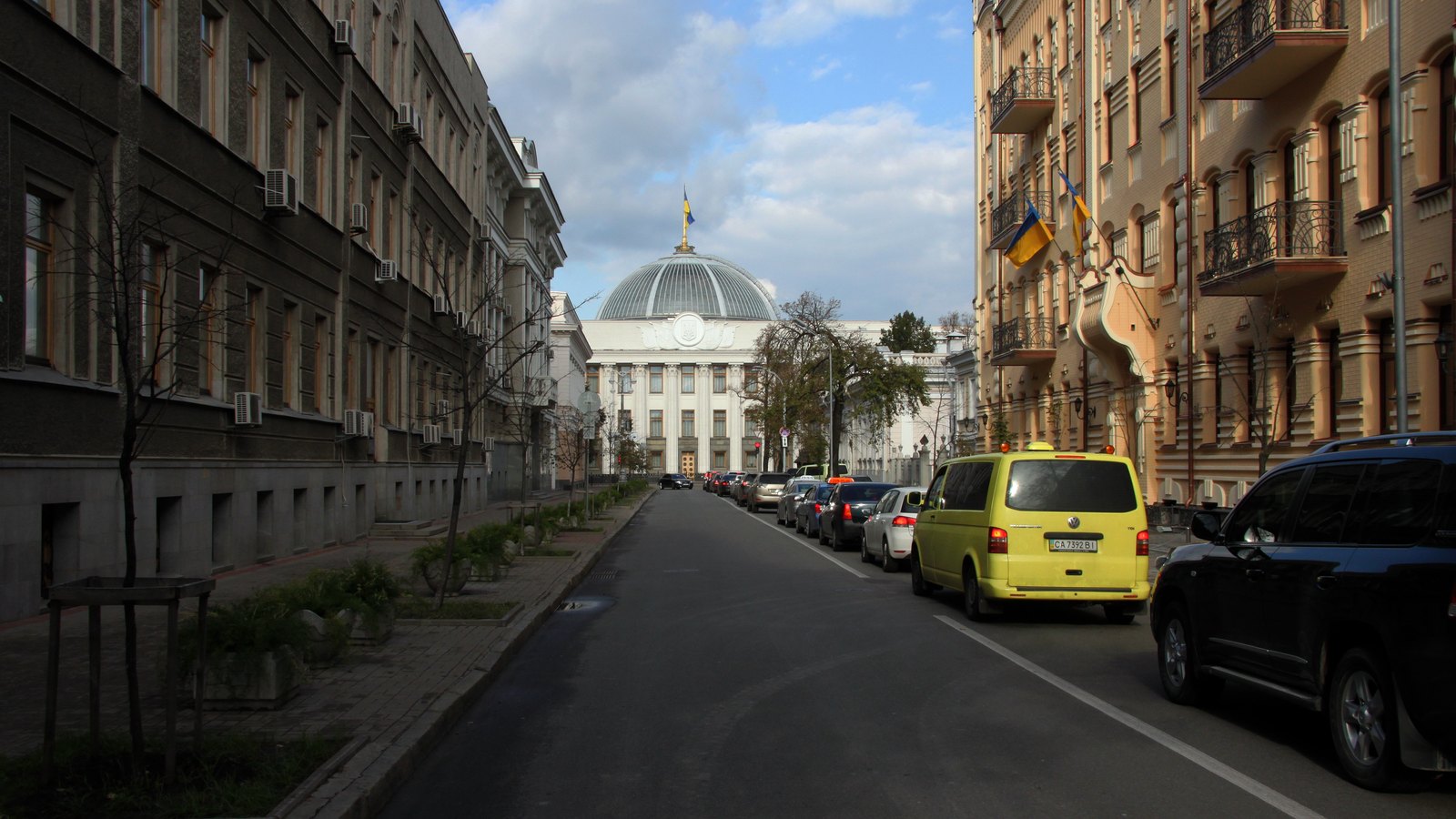 A street lined with apartment buildings leading to a domed government building