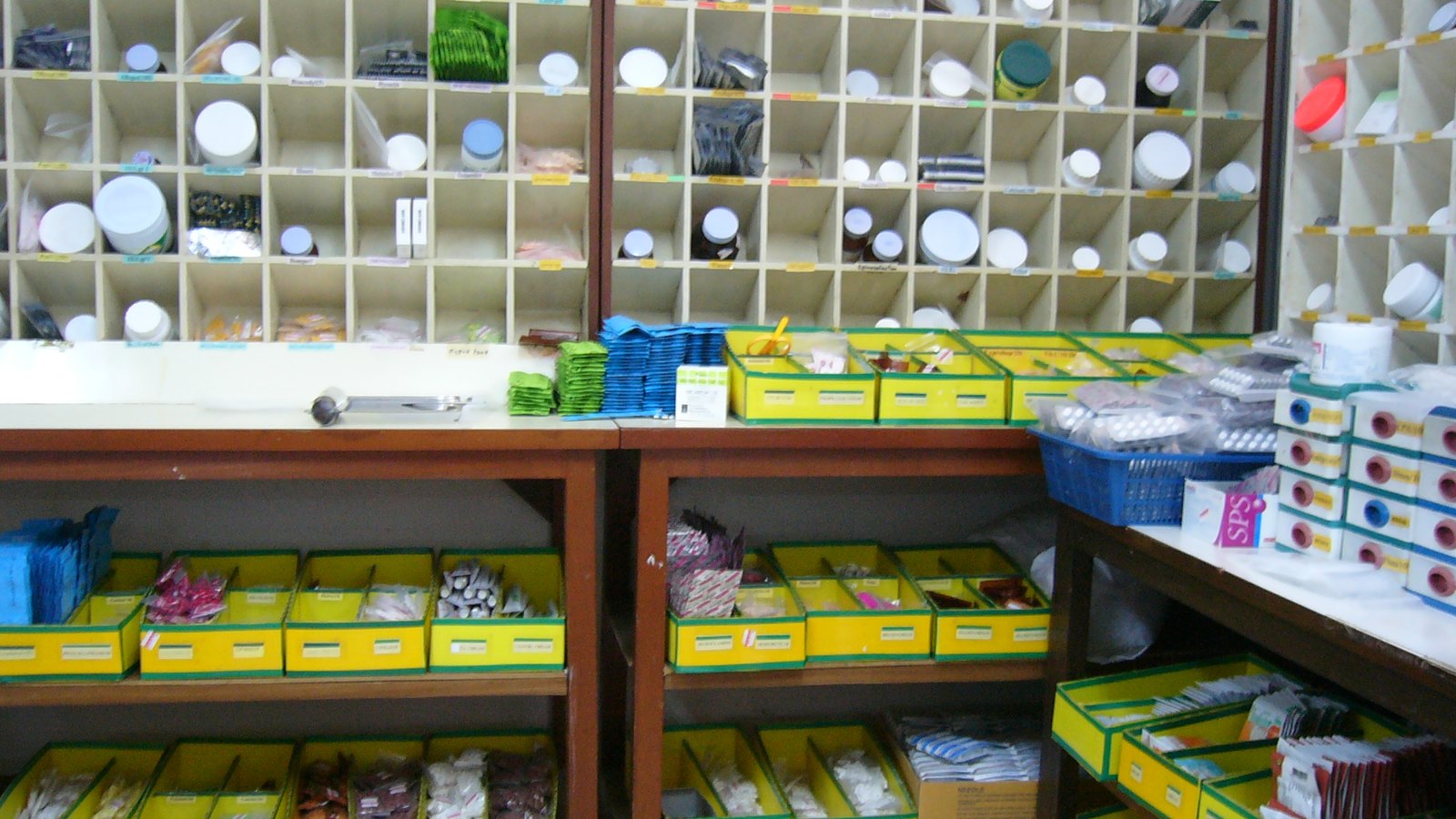 Shelves and yellow trays of medicine packs in a hospital pharmacy