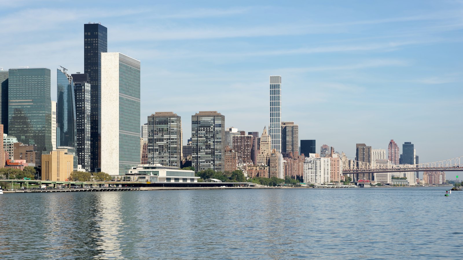 The slab-shaped United Nations Secretariat tower beside the East River, with Manhattan towers behind